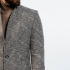 Modern grey wool peacoat layered over brown turtleneck