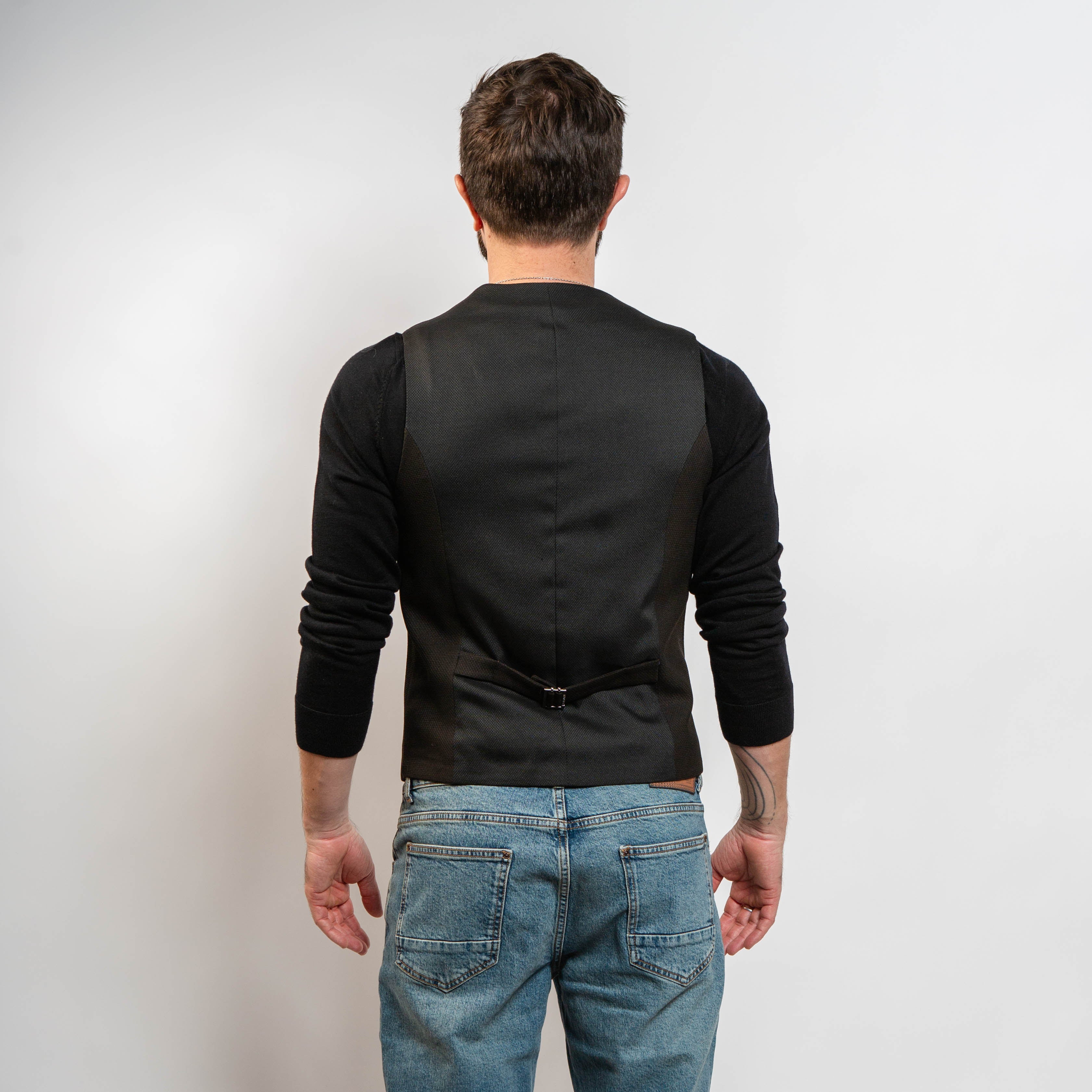 Brown men’s waistcoat styled with jeans and black sweater